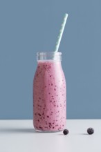 Front view pink smoothie bottle with straw blueberries