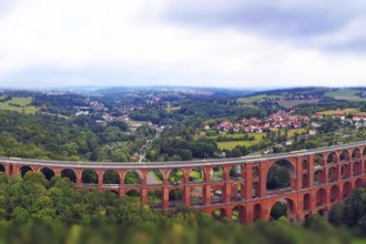 Aerial view of the Göltzsch Valley Bridge, an impressive brick viaduct that spans majestically over