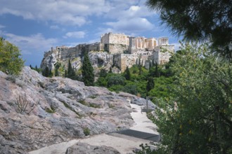 View of Acropolis hill from Areopagus hill in summer daylight with great clouds in blue sky,
