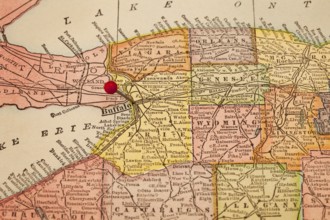 Buffalo and part of New York state on vintage 1920s map with a red pushpin, selective focus