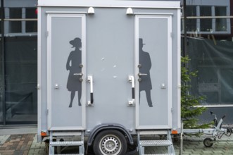 Modern portable toilet trailer with separate entrances for men and women, featuring elegant
