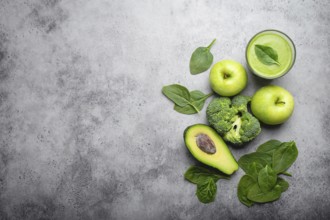 Ingredients for making green healthy smoothie with broccoli, apples, avocado, spinach, stone