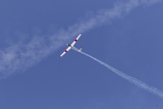 Airshow, glider with contrails against blue sky, Montreal, Province of Quebec, Canada