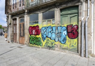 Street graffiti tagged spray painted on building frontages, city of Guimaraes, Portugal