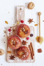Red baked apples with cinnamon, walnuts and honey. Autumn or winter dessert. Top view