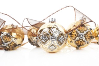 Luxurious antique golden christmas balls decorated with brown ribbon. Traditional festive xmas