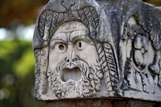 Ancient stone sculpture, stone carving of a mask, Roman theatre, ancient port city of Rome,