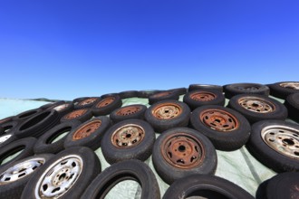 Old wheels, rims and tyres, used here to weigh down the cover of an agricultural silo