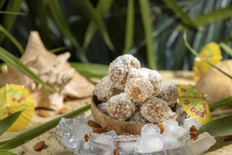 Almond and chocolate confectionery in a coconut on ice cream with umbrellas on sand