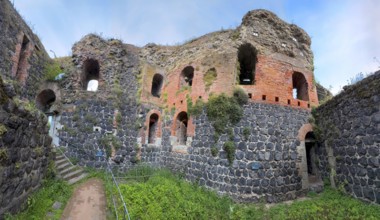 Panoramic photo of interior of northern inner part with partially restored secured masonry of ruins
