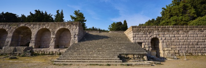 Panorama of a stone staircase and ancient structures with trees in the background, open staircase
