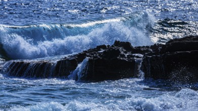 Rugged rocky coastline and foaming spray, on Stecci beach, near Capoliveri, Elba Island, Tuscan