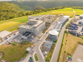 Industrial building complex in green surroundings with streets and hills, construction of the new