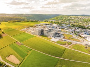 Aerial view of large buildings and green fields on a hill, construction of the new hospital health