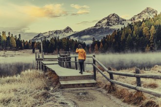Young woman at Lake Staz near Sankt Moritz in the Engadine in Switzerland. Morning atmosphere with