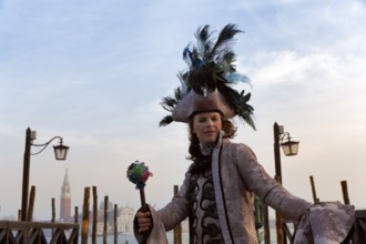 Tourist at the carnival, Venetian costume with hat, disguised man, boat dock at St Mark's Square,