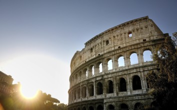 The Colosseum stands majestically against a setting sun, highlighting its ancient stone structure