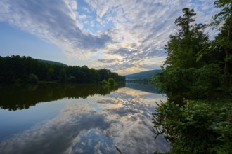 An impressive sky with clouds over a quiet, reflecting river at sunrise, summer, Grünenwört,