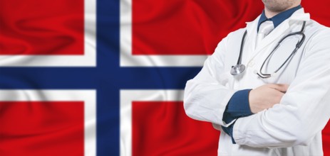 Norway healthcare concept. Male doctor on Norway flag. Doctor with crossed arms on Norway flag