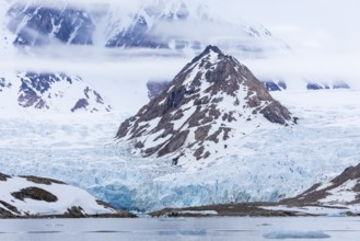 Ice in front of glacier tongue, sea, mountain peak, Smeerenburgbreen, Spitsbergen, Svalbard
