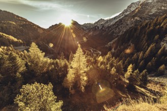 Woman sitting thoughtfully at a feslen at autumn atmosphere during sunset in the Swiss Alps in the