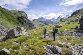 Two mountaineers on a hiking trail in a mountain landscape, descent at Col du Louvie, view of the