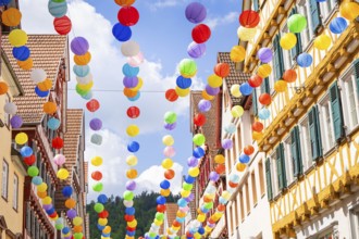 Several rows of colourful balloons over a charming old town, creates a cheerful atmosphere, Calw,