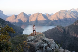 Hiker enjoying sunset at Blyde River Canyon, view of canyon with Blyde River in the evening light,