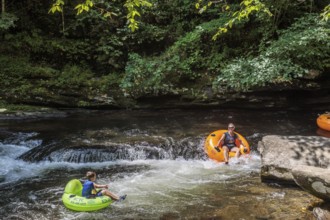 Visitors tubing down Deep Creek in the Smoky Mountains near Bryson City, North Carolina, USA