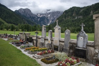 Graves and flowers at a cemetery in front of a mountain landscape, Zgornje Jezersko, Gorenjska,
