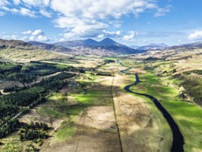 Farms and Mountains over River Dochart and Road A85 from a drone, Perthshire, Scotland, UK