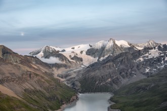 Mountain landscape with turquoise blue reservoir Lac des Dix and summit Mont Blanc de Cheilon, moon