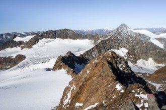 Narrow rocky ridge on the Wilder Freiger summit, picturesque high mountain landscape with snow,
