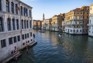 View of the Grand Canal with gondoliers at sunset, picturesque evening mood with palazzos on the