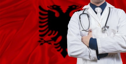 Male doctor with stethoscope on Albania flag. Doctor holding stethoscope on Albania flag