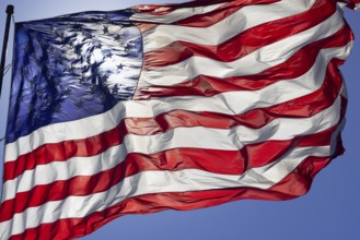 Dramatic backlit american flag waving in the wind