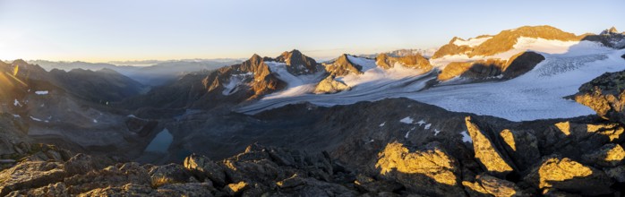 Picturesque high mountain landscape at sunrise with alpenglow, blue glacial lakes, glaciers and
