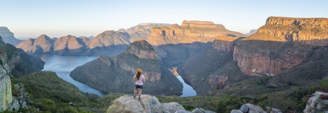 Hiker enjoying sunset at Blyde River Canyon with Three Rondawels peak, view of canyon with Blyde