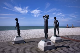 Bronze sculpture La Heure du Bain by Dominique Denry on the beach, sky, blue, behind it beacon Feu