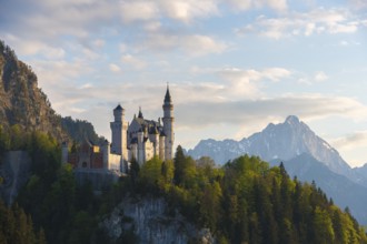 Romantic castle against an Alpine backdrop at dusk, Neuschwanstein, Schwangau near Füssen,