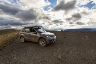 SUV, SUV with roof tent parked next to gravel road F35, Kjalvegur Kjölur, barren stony volcanic