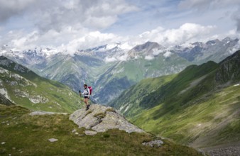 Mountaineer on a rock at the Mittagskögele, view of mountain peaks of the Venediger group and the