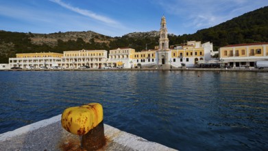 View over the harbour to the monastery with a striking tower and yellow buildings, Holy Week, Bay