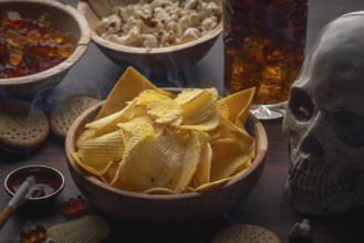Skull and crossbones next to crisps, jelly babies, popcorn, cola and a smoking cigarette