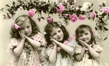 3 girls with flowers, 1900, Three girls in old-fashioned clothes with flowers and pink decorations,