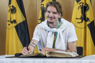 Nick Woltemade signing the Golden Book of the City of Stuttgart. Reception organised by the state