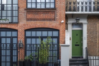 Historic brick building labelled Contractors, green door, Kensington, London, England, United