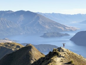 Person with outstretched arms on the hiking trail to Roys Peak Lookout, Lake Wanaka, Wanaka, South