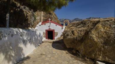 Legend, crab, shell fisherman, chapel with red roof and sea view on a rocky coast, in natural and