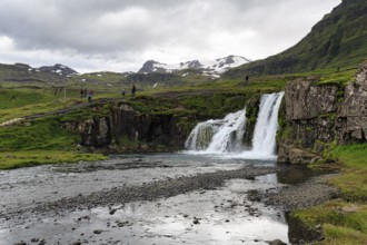 Hikers, tourists at Kirkjufellfoss waterfall, Kirkjufellsa river, Grundarfjördur, Snæfellsnes